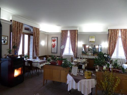 une salle à manger avec deux tables et une cheminée dans l'établissement Hotel La Vie En Rose, à Le Brugeron