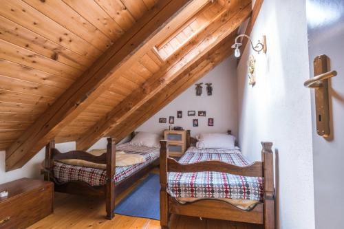 2 Betten in einem Dachzimmer mit Holzdecken in der Unterkunft Pochi passi dalle piste di Les Arnaud in Bardonecchia