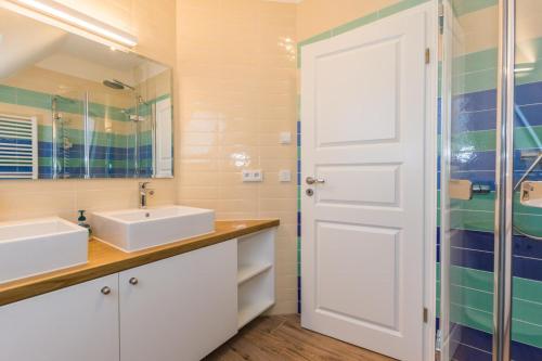 a bathroom with two sinks and a glass shower at Buten un Binnen in Zingst