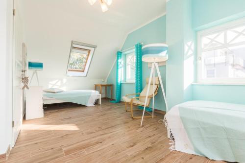 een slaapkamer met blauwe muren en een houten vloer bij Buten un Binnen in Zingst