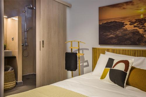 a bedroom with a bed and a shower at Ionian Village in Lixouri