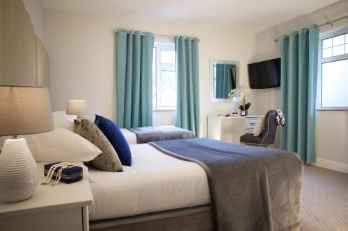 a bedroom with a large bed with blue curtains at Westport Heights in Westport