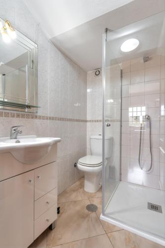 a bathroom with a toilet and a sink and a shower at Casa Do Norte in Ovar