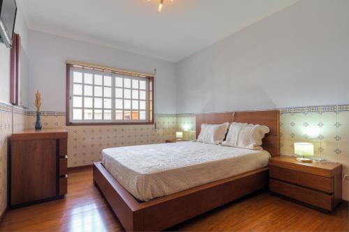 a bedroom with a large bed and two night stands at Casa Do Norte in Ovar