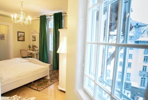 een slaapkamer met een bed en een groot raam bij Royal Residence 1901 in Sinaia