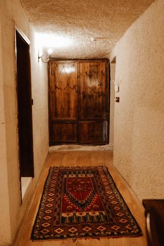 a large wooden door in a room with a rug at Asteria Cave Hotel in Goreme