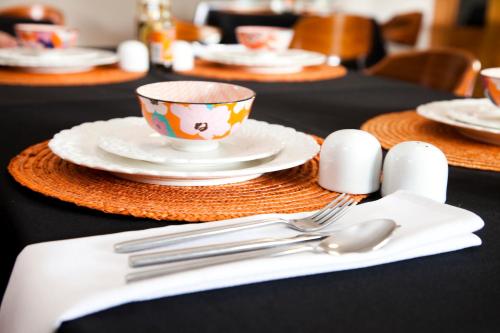 una mesa con platos y utensilios y una taza en The Gables Middelburg MPU, en Middelburg