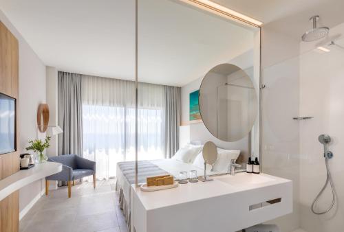 a bedroom with a bed and a mirror and a sink at Barceló Conil Playa - Adults Recommended in Conil de la Frontera