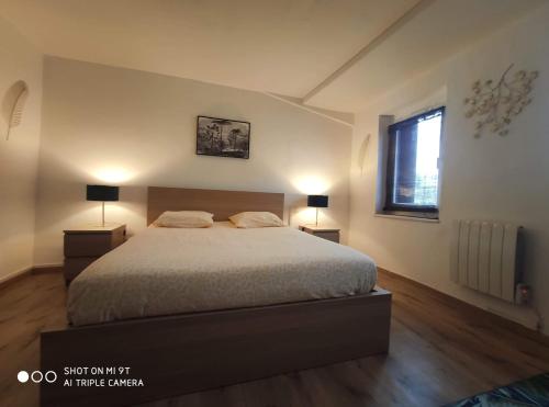 - une chambre avec un lit, deux lampes et une fenêtre dans l'établissement La petite maison dans la bastide, à Carcassonne