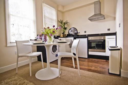 cocina con mesa blanca y sillas en una habitación en Noa Residence, en Oxford