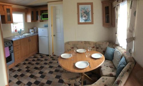 una pequeña cocina con mesa y sofá en Thurso Bay Holidays, en Thurso