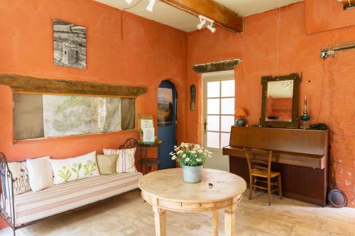 a living room with a couch and a piano at Poterie de Pierroux in Roussillon