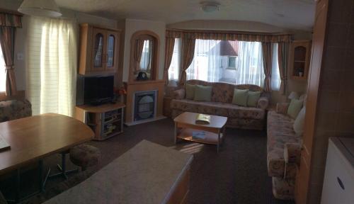 a living room with a couch and a tv at Thurso Bay Holidays in Thurso