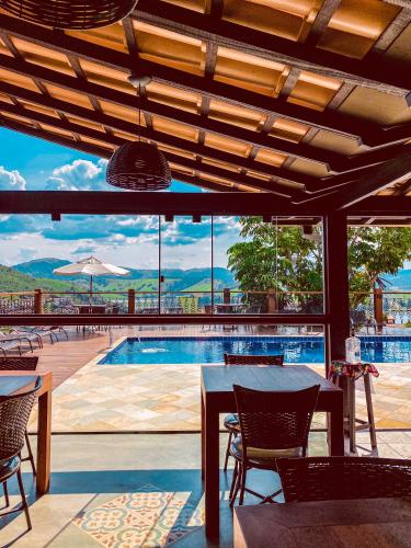 a patio with a table and chairs and a swimming pool at Pousada Buena Vista in Capitólio