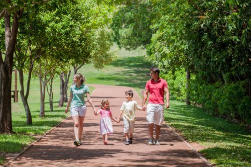 a family walking down a path in a park at Blue Tree Thermas de Lins Resort in Lins
