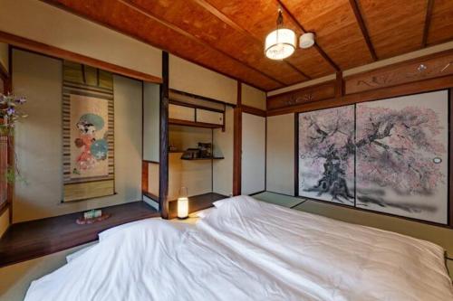 a large bed in a room with paintings on the walls at Yamagata Kyomachihatago Kyotostation Mae in Kyoto