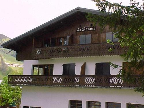 ein großes Gebäude mit einem Balkon darauf in der Unterkunft Manoir 1 appt Les Gets in Les Gets