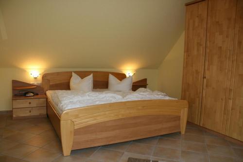 a bedroom with a wooden bed with white sheets and pillows at Strandstr_41 Fewo 1 in Zingst