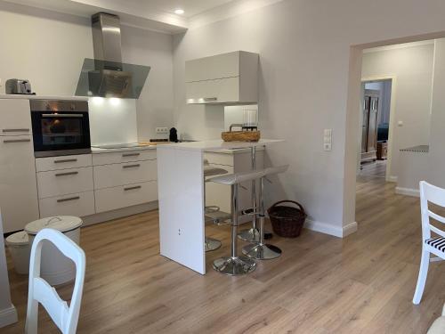 a kitchen with white cabinets and a table and chairs at Gestorfer Kötnerhof Business und Landlust in Springe