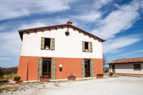 a large white and orange building with green shutters at Cà Vincenzona, Wellness Area in Faenza
