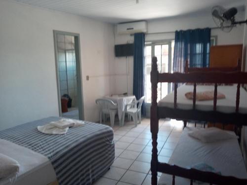 Hotel e Restaurante Recanto da Lagoa في لاغونا: غرفة نوم بسريرين بطابقين وطاولة وكراسي