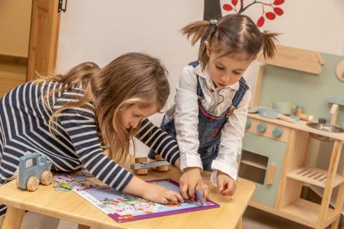 two young girls playing with a toy at a table at Maison Valentina in Merano