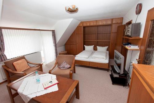 ein kleines Wohnzimmer mit einem Bett und einem Tisch in der Unterkunft Strandrose in Wenningstedt-Braderup