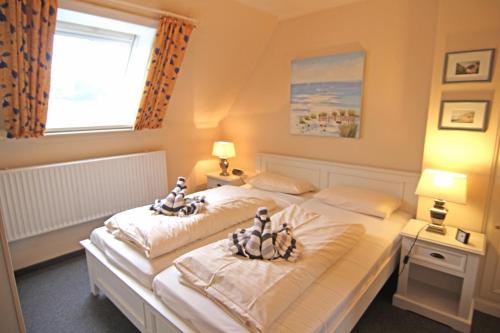 a bedroom with two beds with dolls on them at Moby Dick im Haus Käpt'n Andresen in Westerland