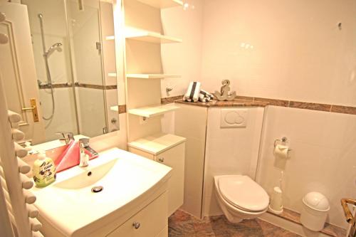 uma casa de banho branca com um lavatório e um WC em MS Viktoria em Westerland