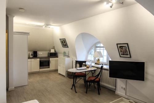 a living room with a table and a kitchen at Tina im Friesenhaus Sieben-Linden in Archsum