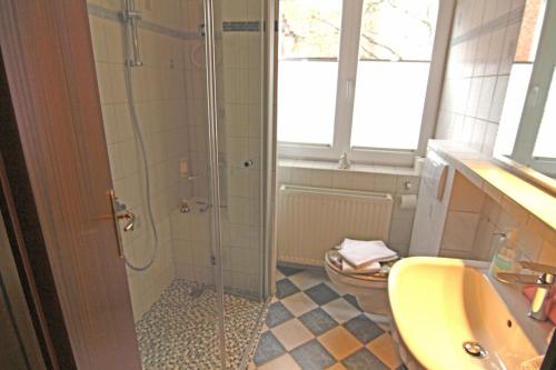 a bathroom with a shower and a sink and a toilet at Hella in Westerland