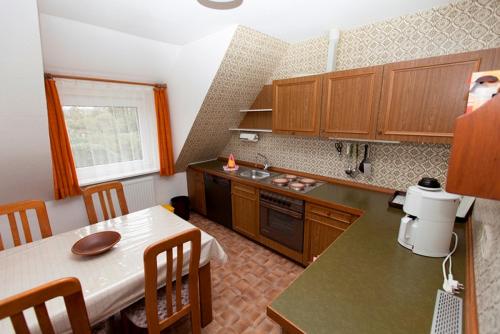eine Küche mit einem Tisch und eine Küche mit einer Arbeitsplatte in der Unterkunft Strandiris in Wenningstedt-Braderup