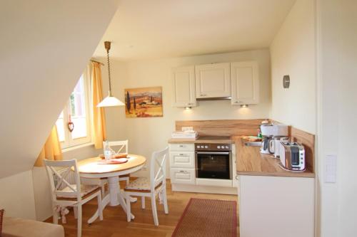 a kitchen with a table and a table and chairs at Sünje in Westerland