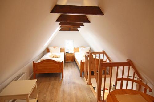 um quarto no sótão com 2 camas e uma escada em Westen em Westerland