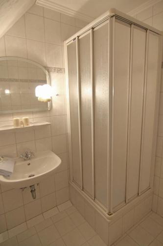 a white bathroom with a sink and a mirror at Erna im Friesenhaus Sieben-Linden in Archsum