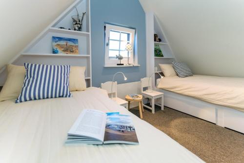 a bedroom with two beds and a book on the bed at Sylt Liebe in Wenningstedt
