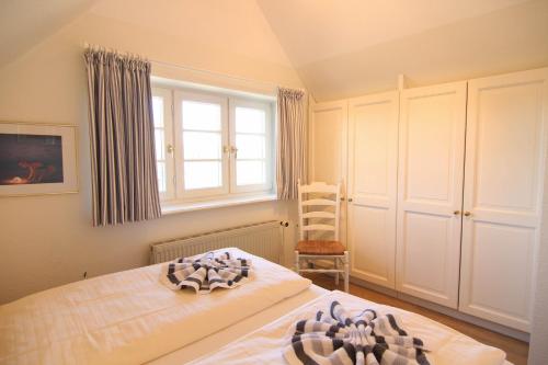 ein Schlafzimmer mit einem Bett, einem Fenster und einem Stuhl in der Unterkunft Christine - Munkmarsch in Munkmarsch