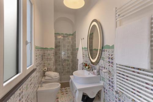 a bathroom with a sink and a toilet and a mirror at Antica Rheginna Luxury Room in Minori