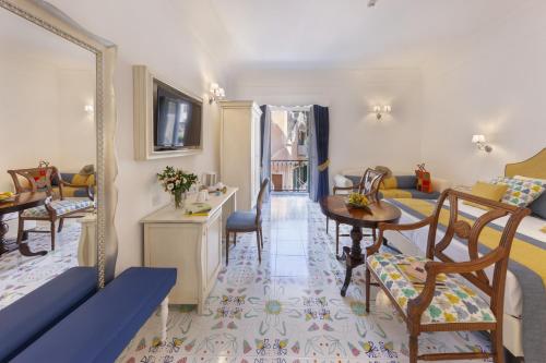 a living room with a table and a mirror at Antica Rheginna Luxury Room in Minori