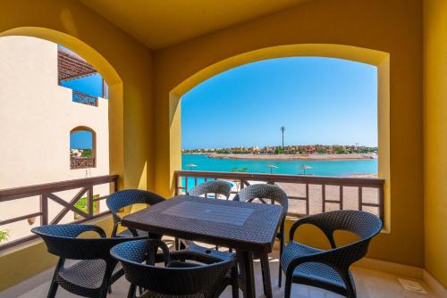 a balcony with a table and chairs and a view of the ocean at VESTA - El Gouna Residence in Hurghada