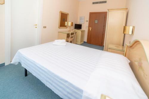 a large white bed in a hotel room at Hotel Della Torre in Stresa