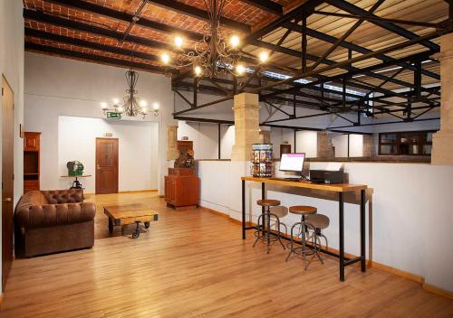 メキシコシティにあるHotel MX centroのスツールとソファ付きのバーが備わる客室です。