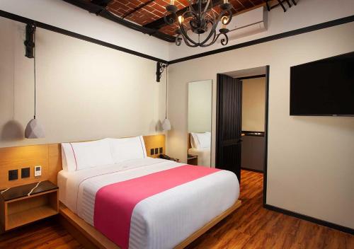 - une chambre avec un grand lit et une télévision à écran plat dans l'établissement Hotel MX centro, à Mexico