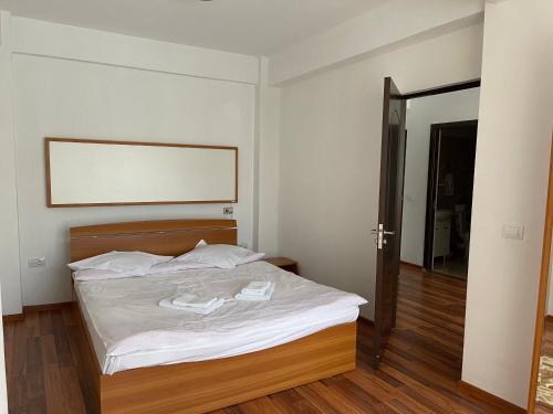 a bedroom with a bed with a wooden head board at Olanesti Apartament in Băile Olăneşti