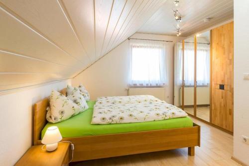 a bedroom with a green bed in a room at Ferienwohnung Lauser Dg in Herdwangen-Schönach