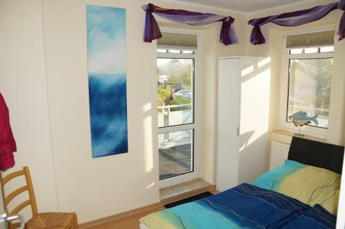 Schlafzimmer mit einem Bett und einem Fenster in der Unterkunft Hafenstr.35 Villa Verena in Zingst