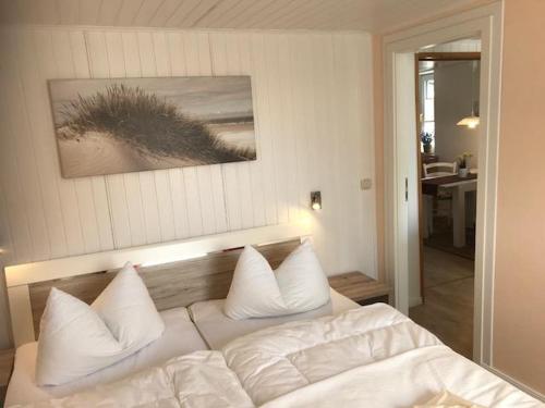 a bedroom with a bed with white sheets and pillows at Haegerende _Alte Liebe_ in Groß Kirr