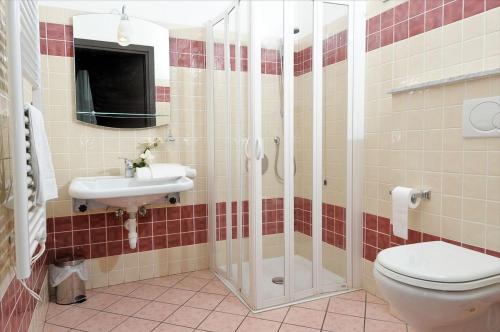 a bathroom with a shower and a toilet and a sink at Hotel Chopin in Genova