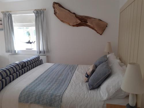 um quarto com uma cama com almofadas e uma janela em The Cobblers Bed and Breakfast em Bishampton