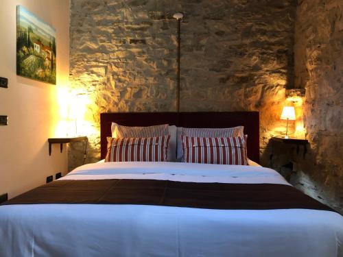 a bedroom with a large bed with a stone wall at Cascina Bertolotto Wine Resort in Spigno Monferrato